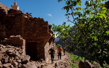 People walking around a stone building