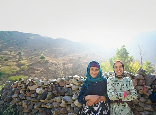 Two women standing in front of rock wall