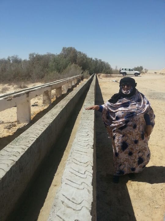 woman standing beside water channel