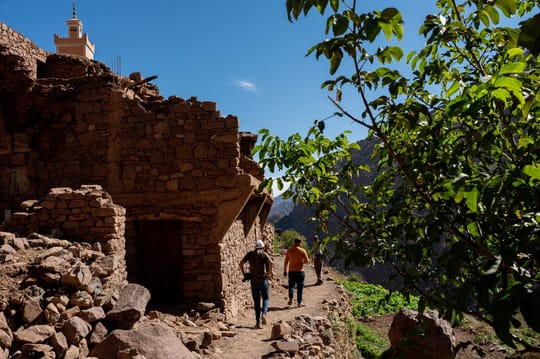 People walking around a stone building